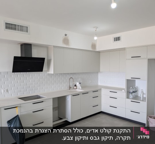 מטבח מודרני עם ארונות לבנים וקולט אדים שחור